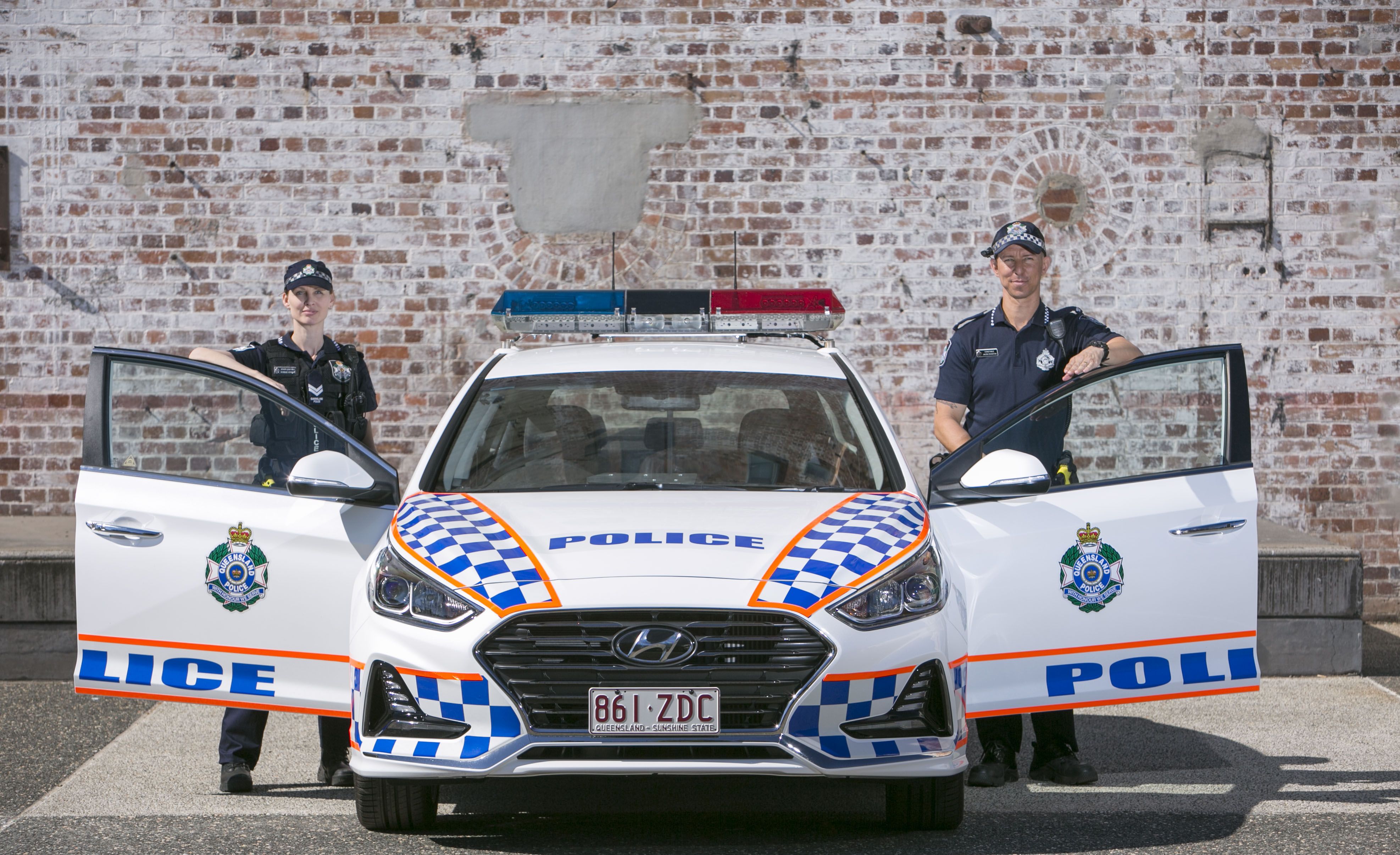 Officers next to a police car