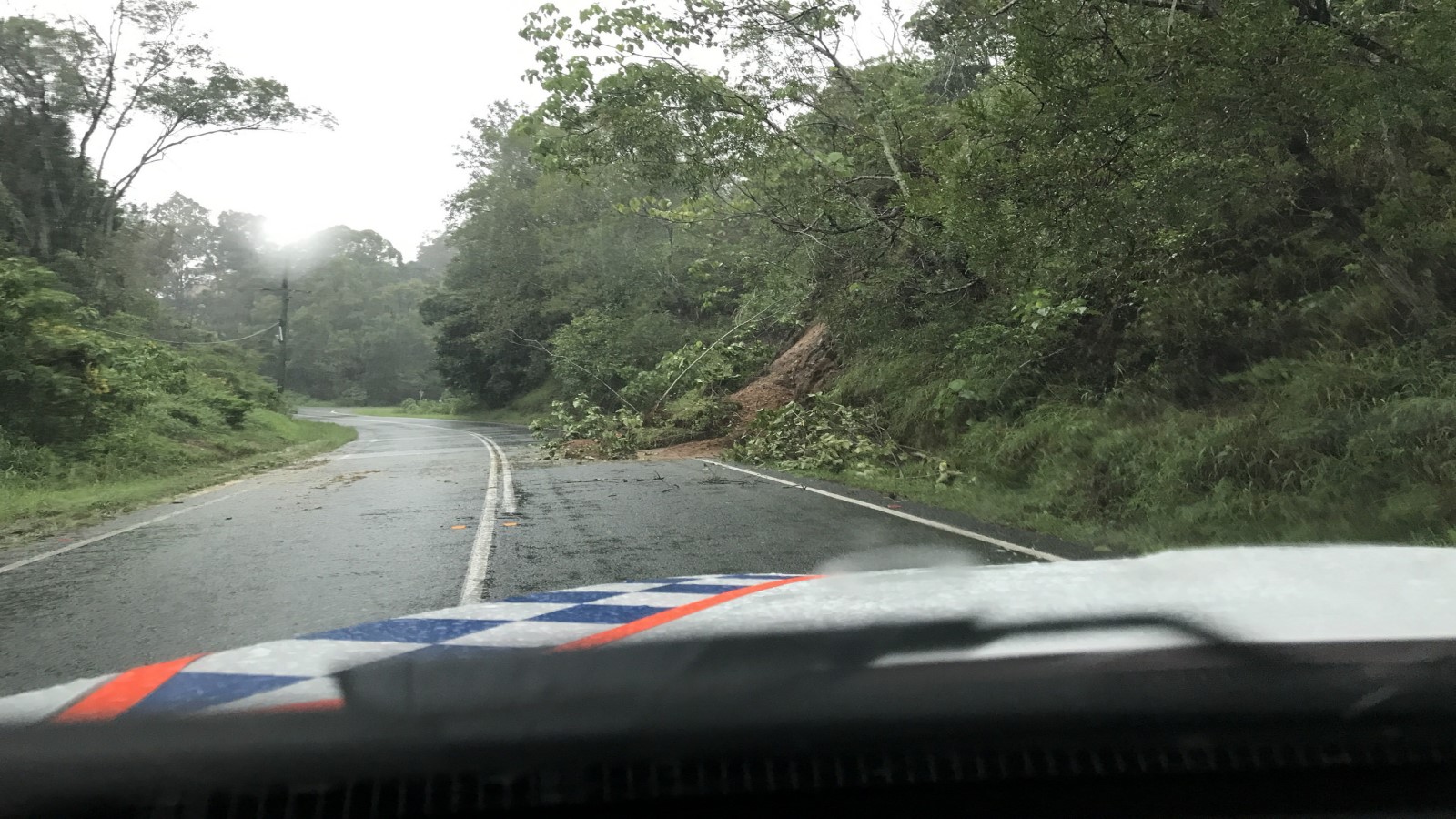 Landslide covering a road from the view of a police car