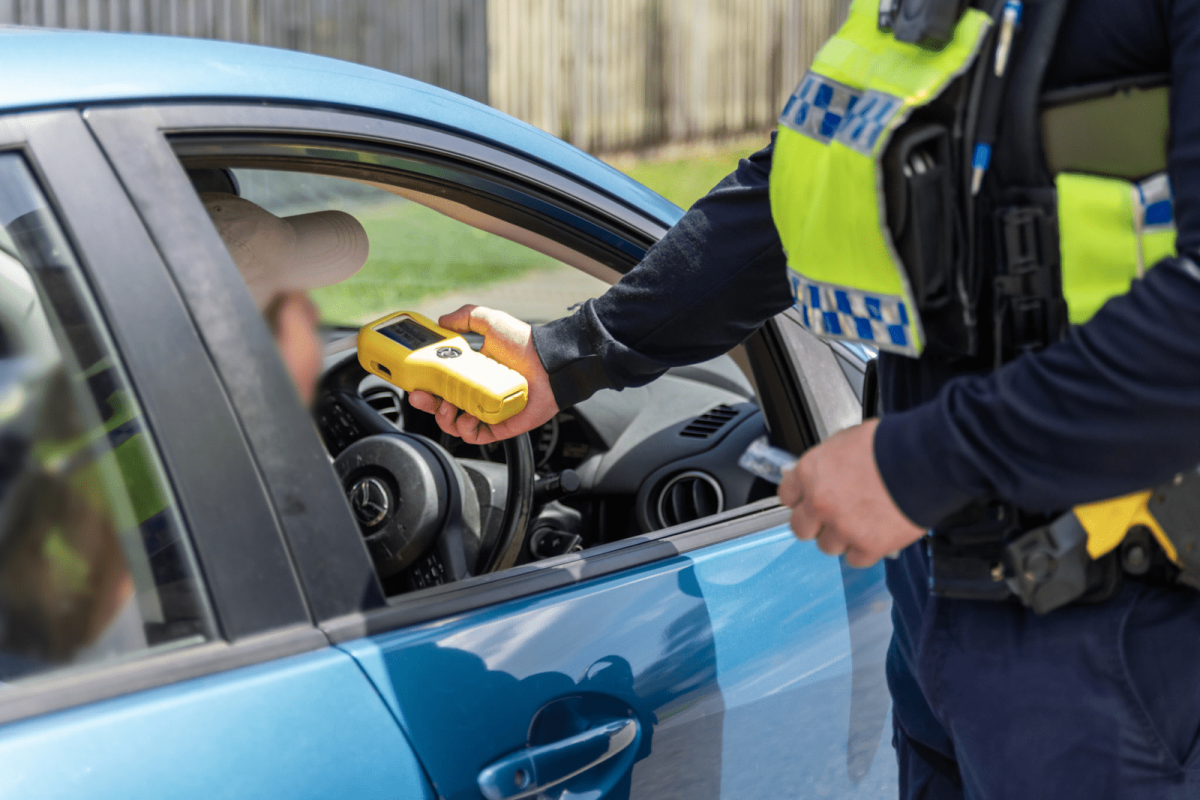 police officer performing roadside breath test