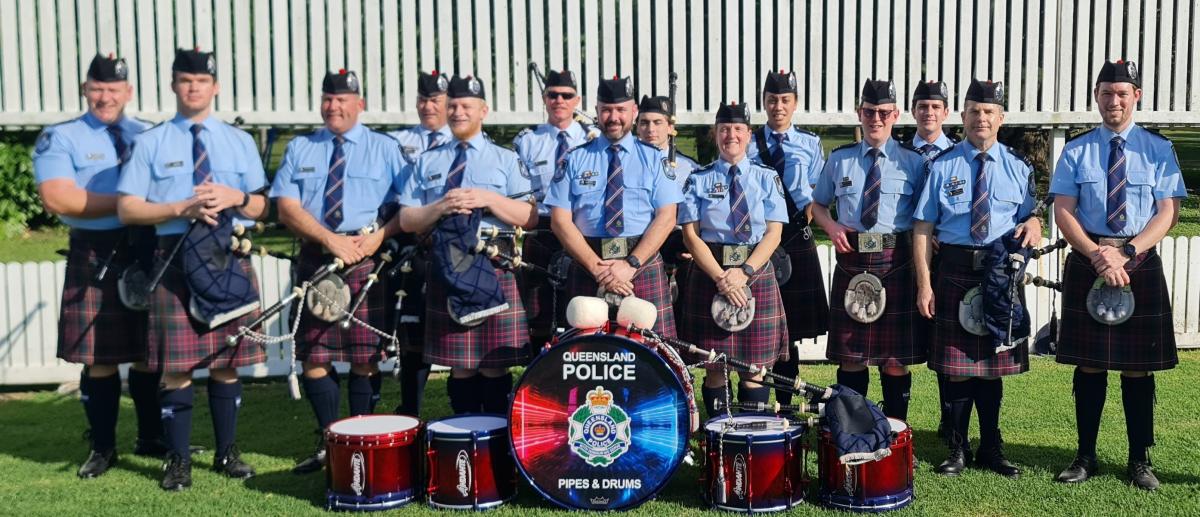 Queensland Police Pipes and Drums members lined up behind their drums.