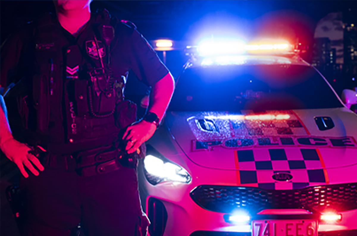 police man standing in front of police car